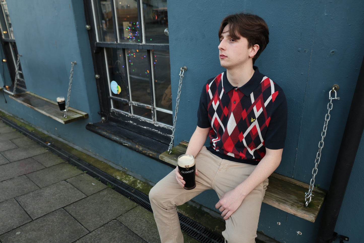 Lyle & Scott cotton argyle short sleeve knitted polo shirt in dark navy with red cherry accents, featuring a classic collar and knit texture.