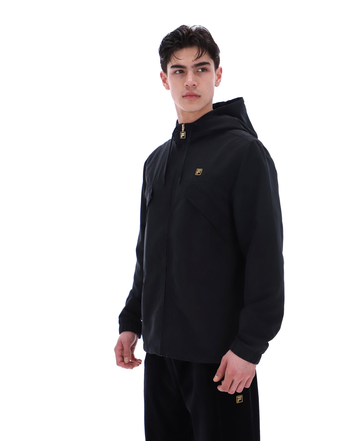 Black Fila Gold lightweight jacket with sleek design, shown on a model with a standing collar and zip closure.