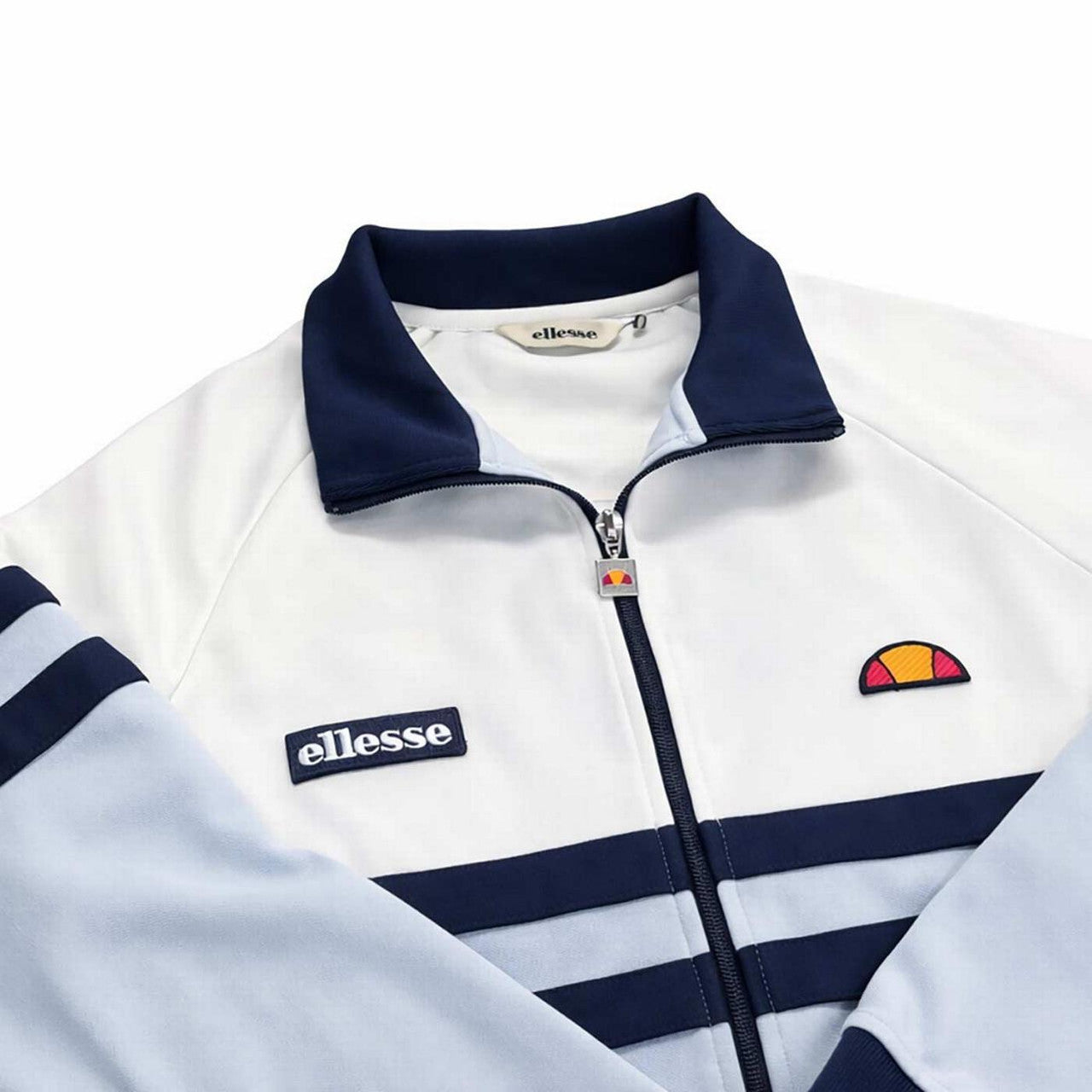 Ellesse Rimini retro track top in off-white and light blue, close-up view showing fabric texture and brand logo.