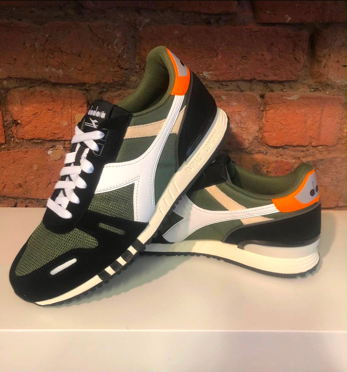 Diadora Titan Trainer shoes in Kombu Green, black, and white with sporty design and cushioned sole for athletic wear.