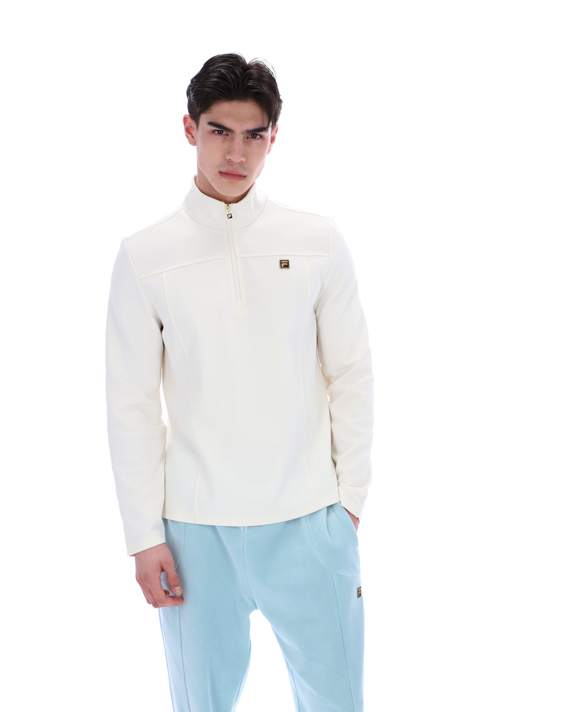 Fila Gold Hogan quarter zip jumper in coconut milk color, featuring a high collar and ribbed cuffs, displayed on a hanger.