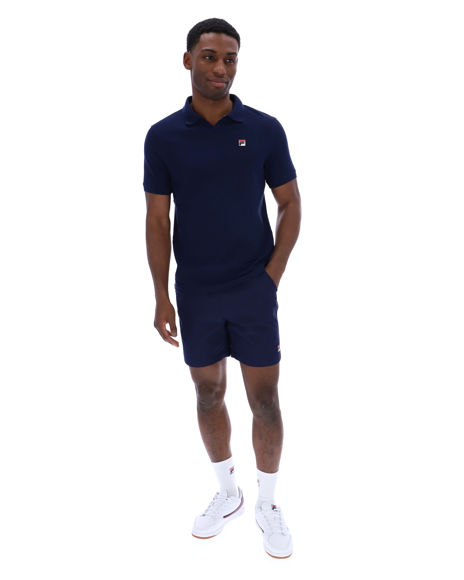 Fila Tristiano navy polo shirt displayed on a hanger, showcasing the classic collar and embroidered logo on the chest.