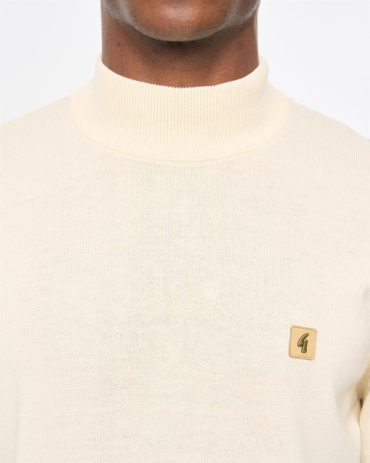 Cream Gabicci Vintage Duke turtle neck knitwear, close-up of soft fabric and stylish collar detail.