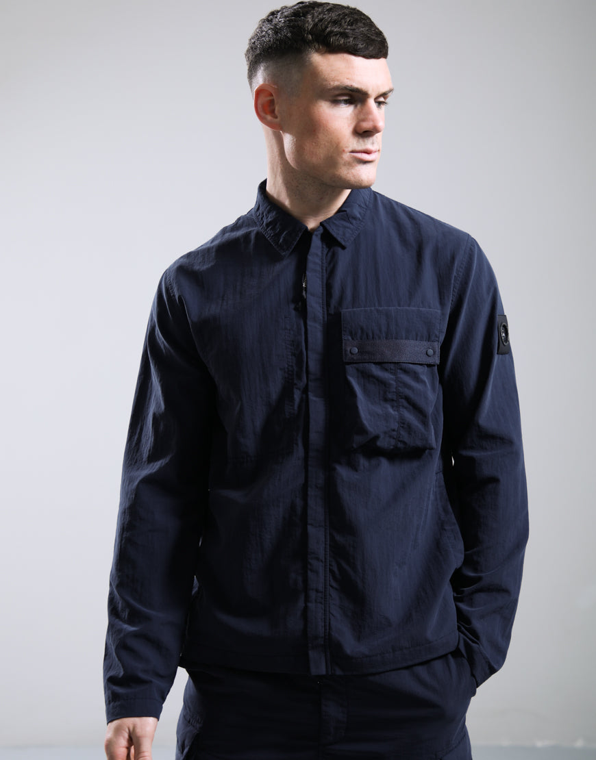 Marshall Artist Woodvale Overshirt Navy jacket displayed on a hanger, featuring a stylish navy overshirt with button details.