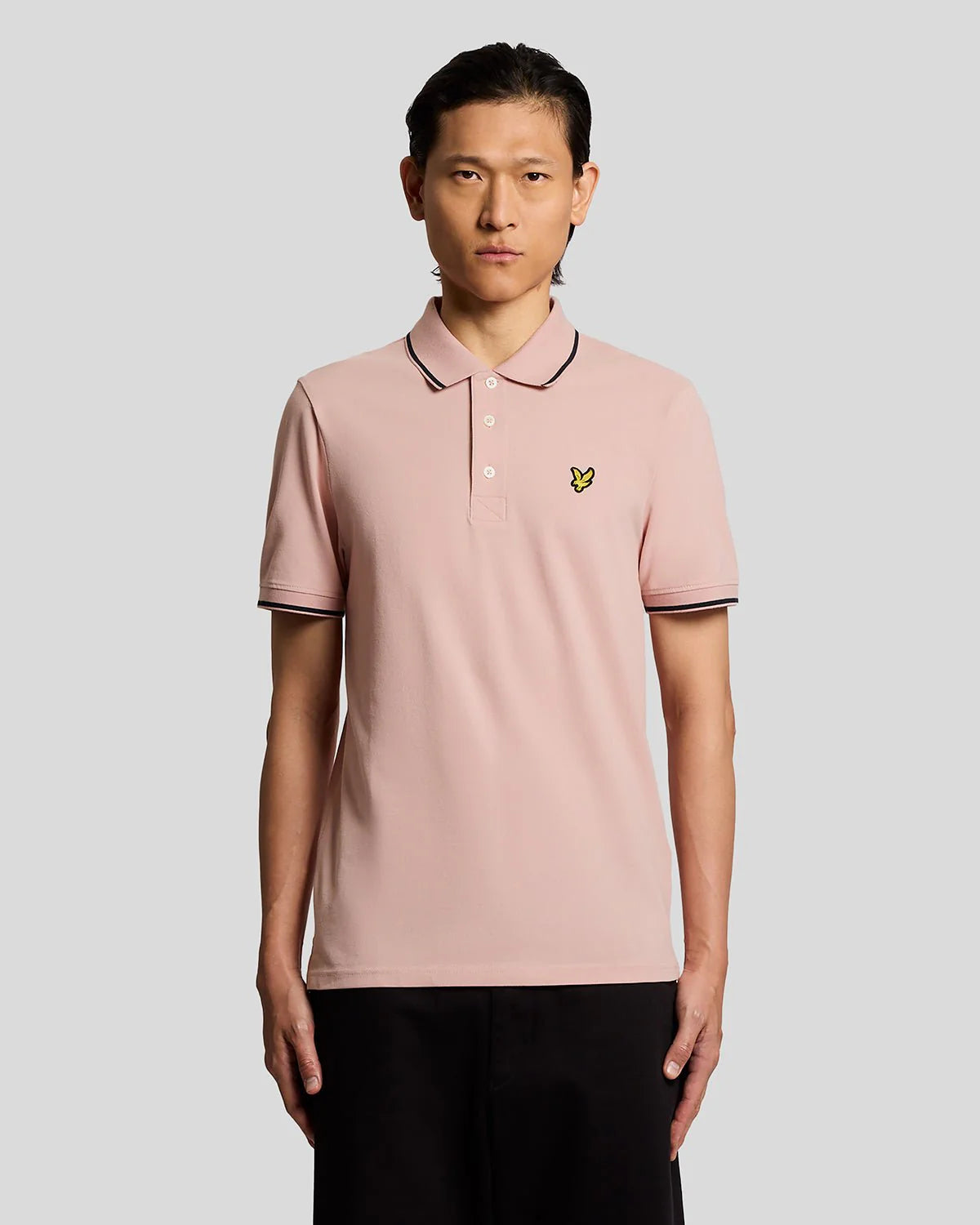 Men's Lyle & Scott polo shirt in pink grapefruit and dark navy with tipped collar and logo, made from comfortable cotton fabric.